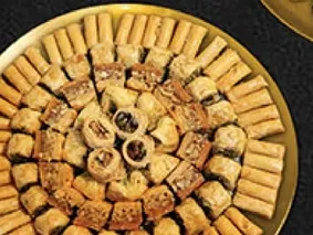 A variety of traditional Arabic sweets, including baklava and other pastries.