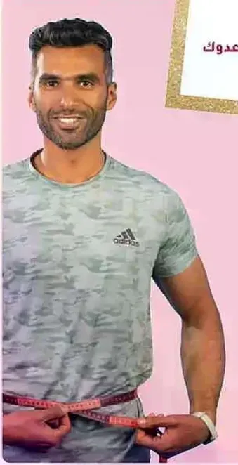 رجل يرتدي تي شيرت رمادي مموه ويقيس خصره بشريط قياس.