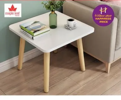 طاوله مربعه حديثه بسطح ابيض وارجل خشبيه، مثاليه لغرف المعيشه او مناطق الطعام.