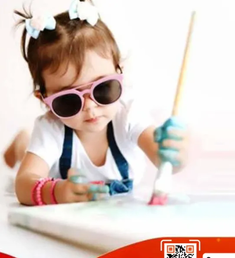 طفل لطيف يرسم وهو يرتدي نظارات شمسيه.